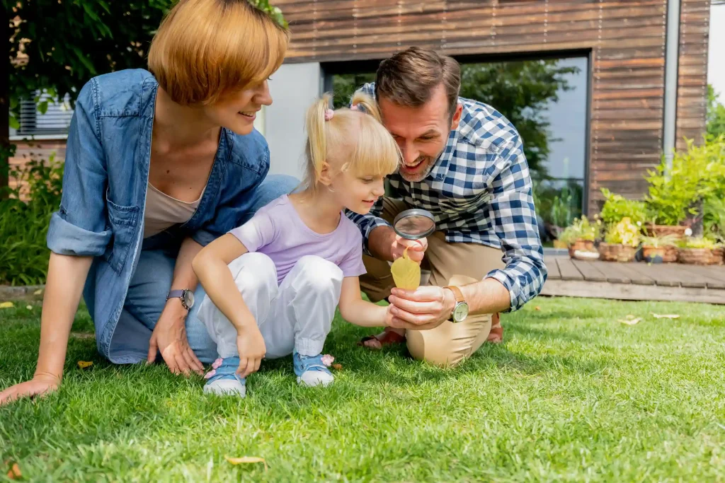 A family sitting on lawn. Lawn Care Tips for Homeowners in British Columbia