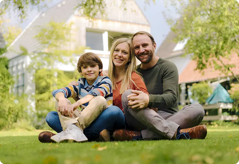 a family sitting on lawn grass.