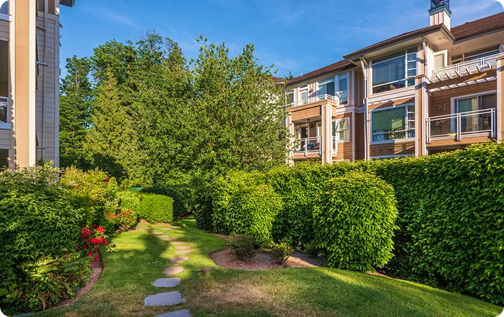 Landscaped lawn path and clipped hedges outside an apartment complex, multi-residential lawn care in Vancouver