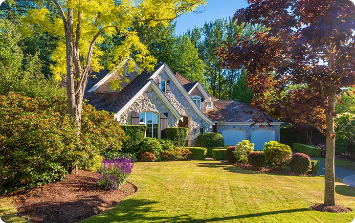 Landscaped front yard with mature trees and shrub beds for rental property lawn care in Vancouver