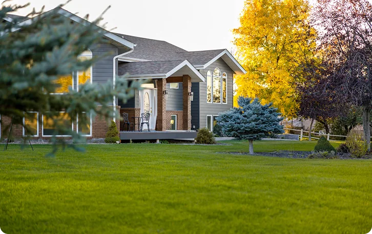 Two-storey home with a broad lawn and autumn trees, maintained through property lawn care in Vancouver